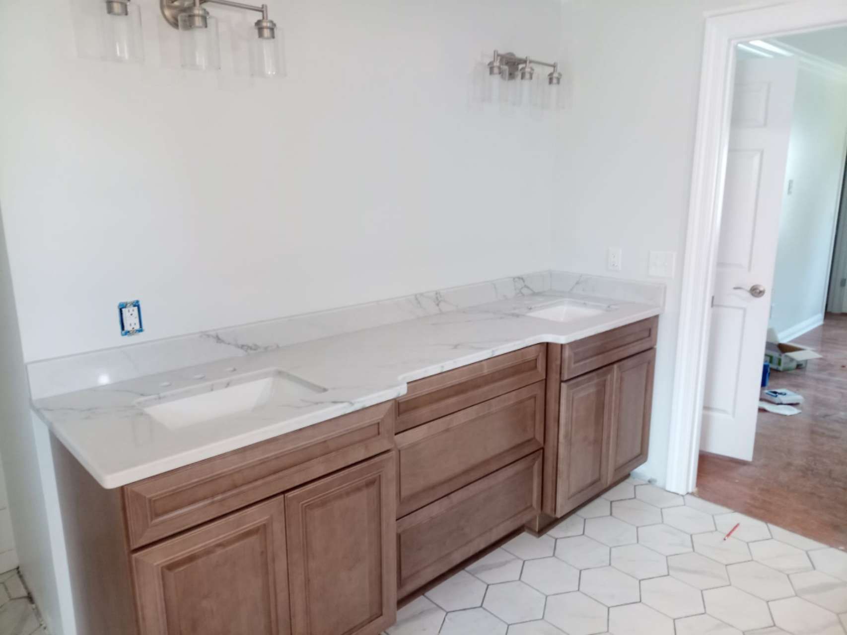 A bathroom with two sinks and wooden cabinets.