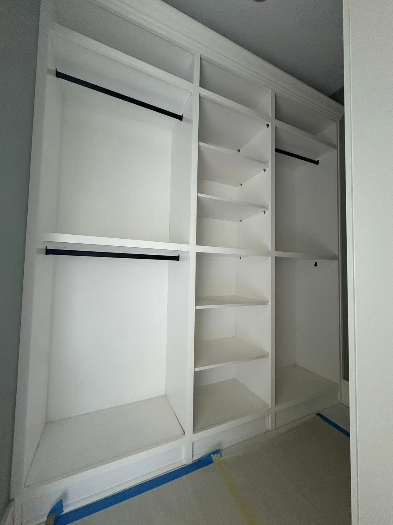 A closet with a lot of shelves and clothes racks.