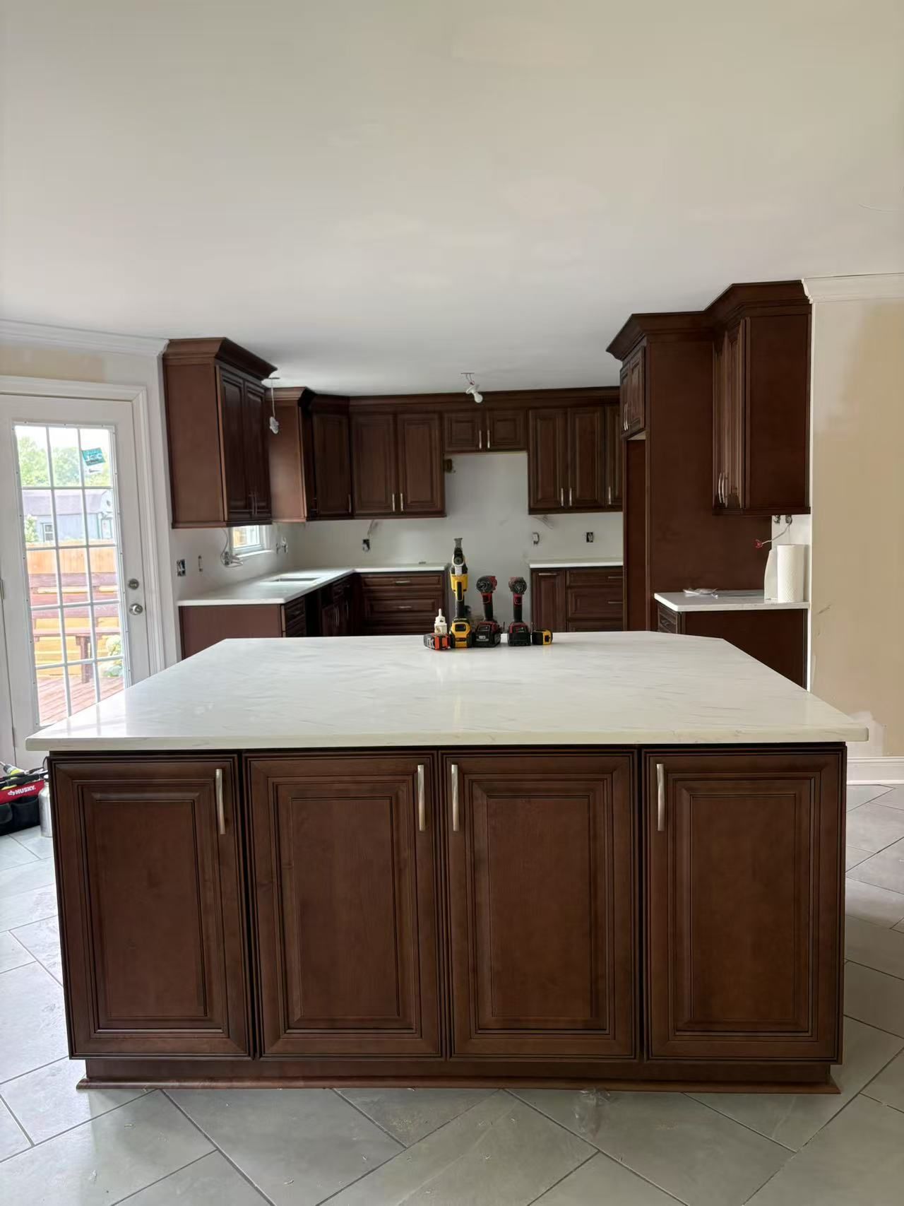 A kitchen with brown cabinets and a white counter top.