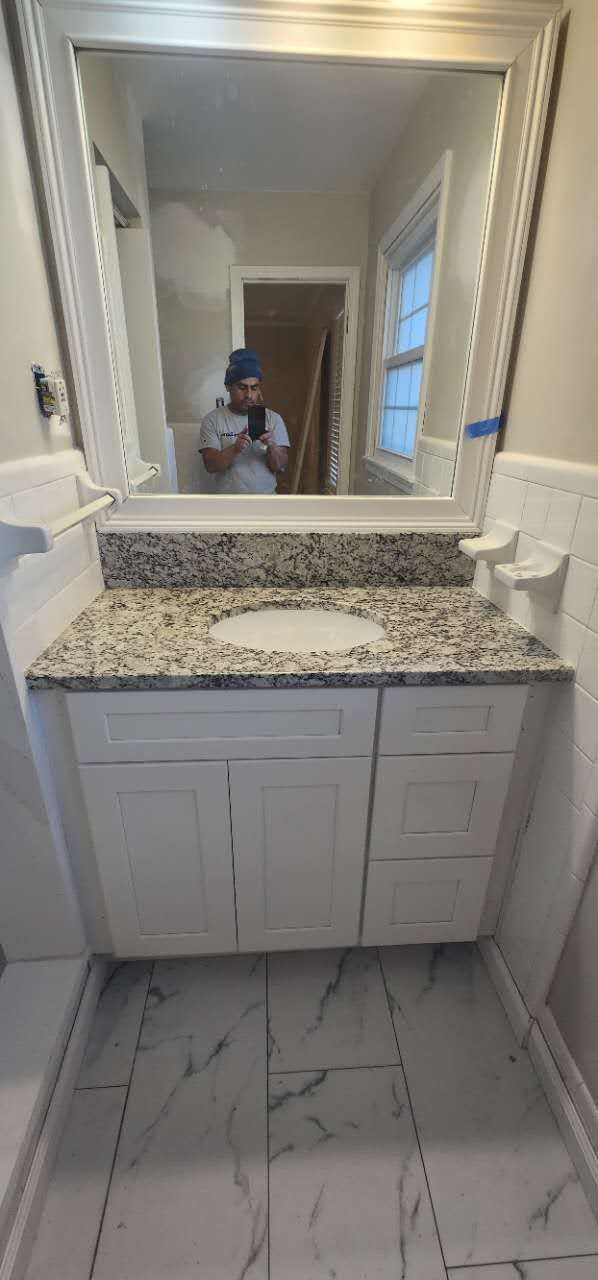 A man is taking a picture of himself in a bathroom mirror.