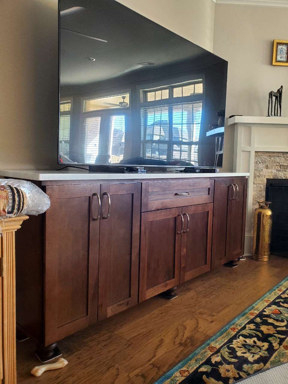 A large flat screen tv is sitting on top of a wooden entertainment center.