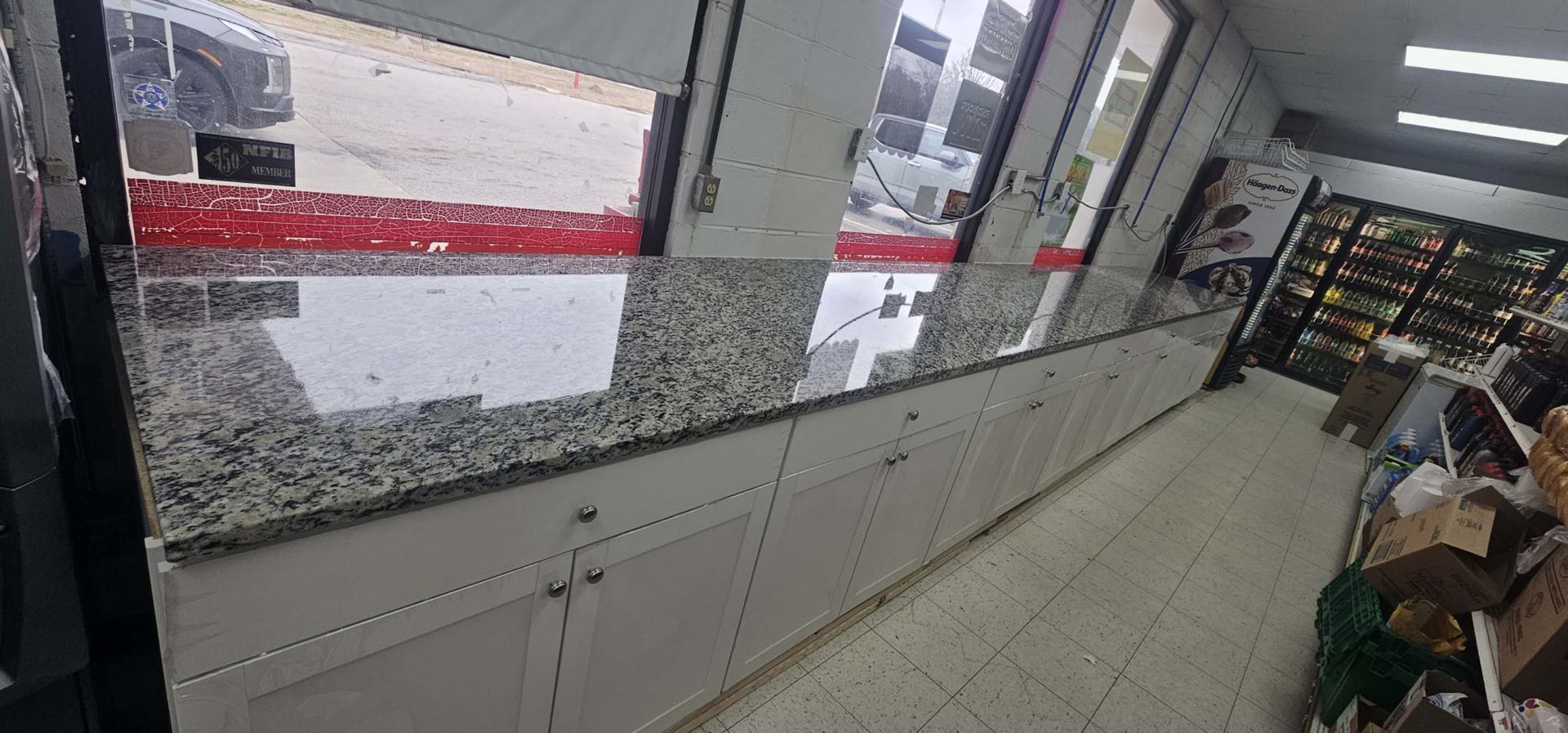 A kitchen with granite counter tops and white cabinets in a store.
