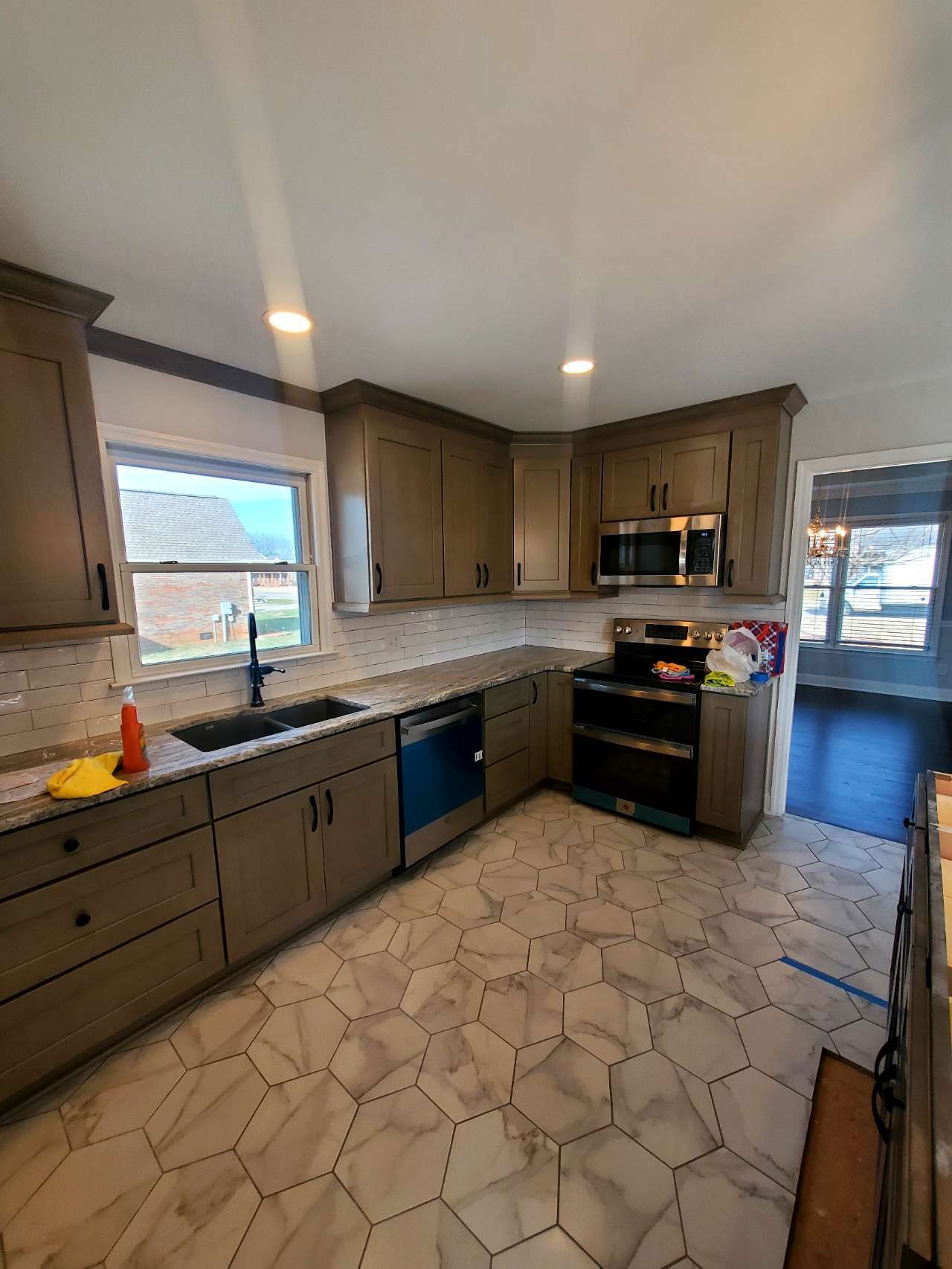 A kitchen with stainless steel appliances, a sink, and a window.