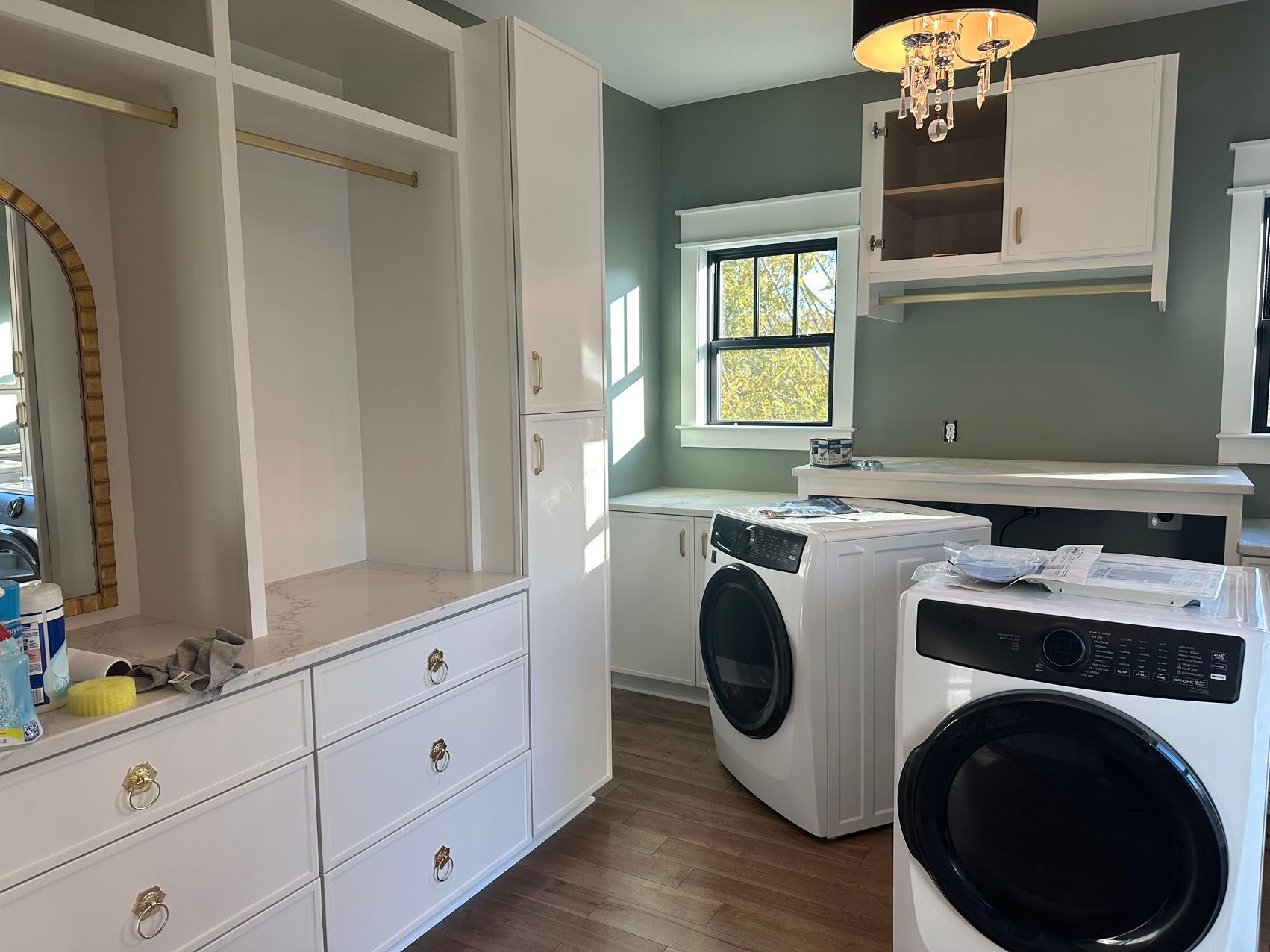 A laundry room with a washer and dryer and a mirror.