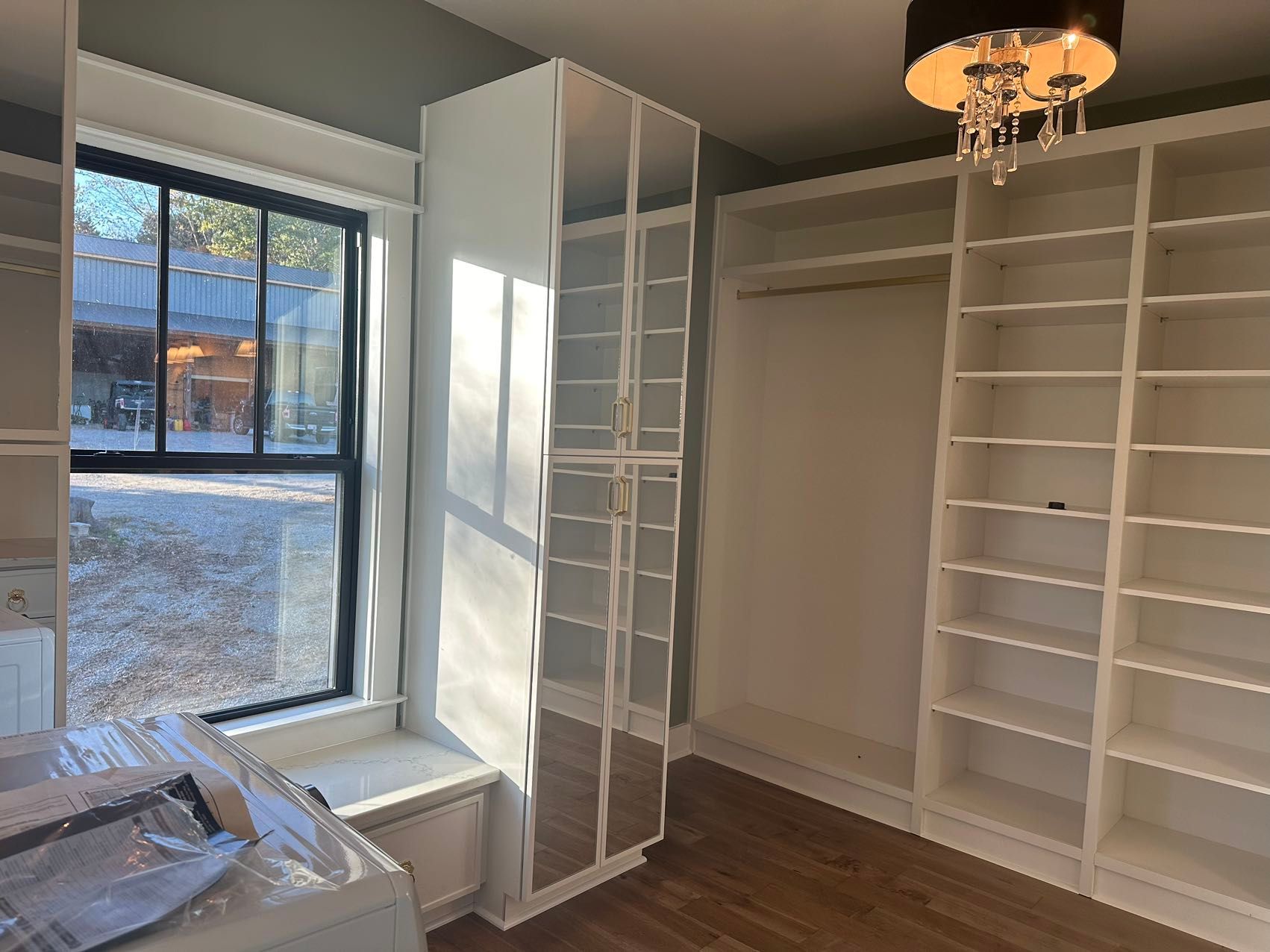 A walk in closet with lots of shelves and a window.