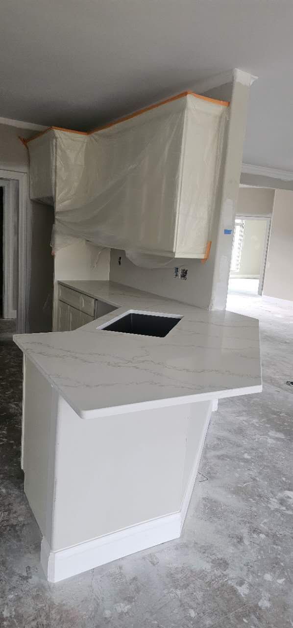 A kitchen with a large island and a sink in it.