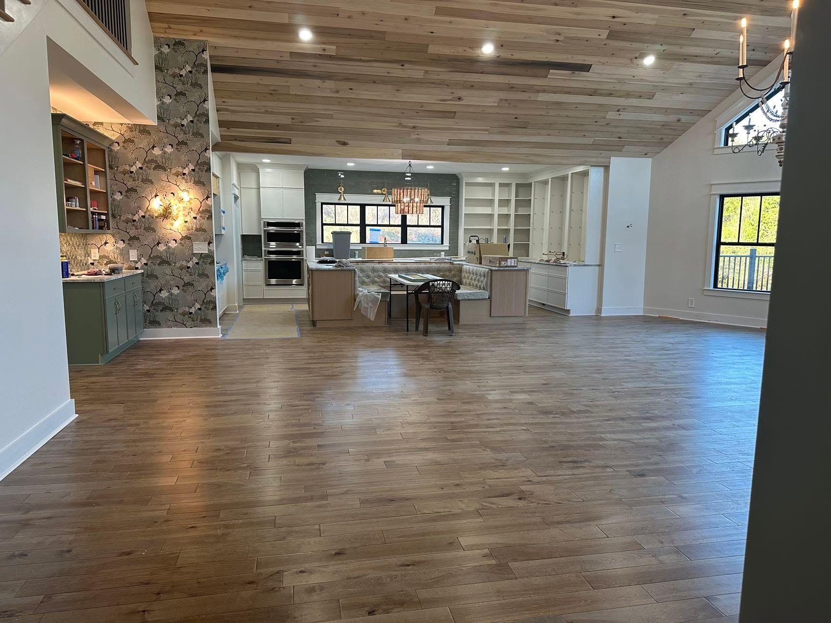 A large empty room with hardwood floors and a wooden ceiling.