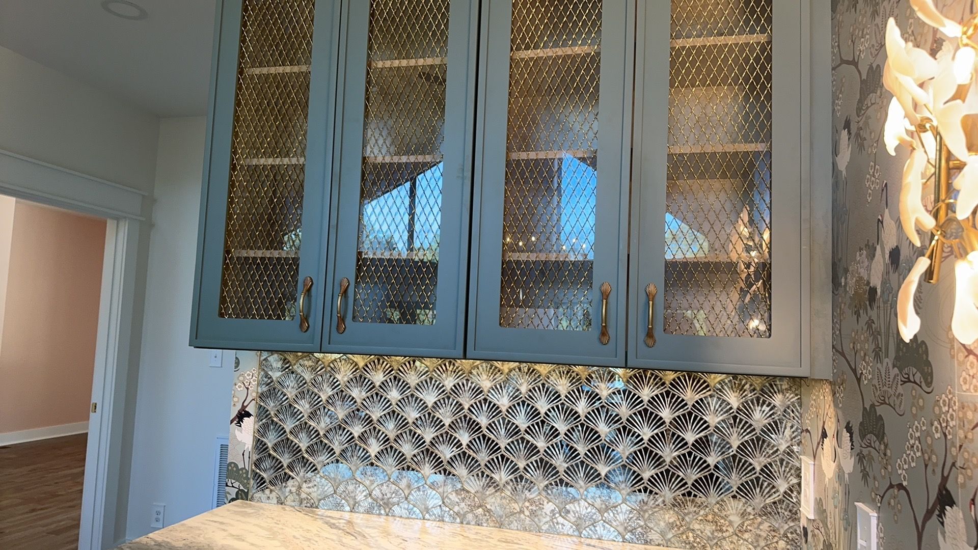 A kitchen with blue cabinets and a marble counter top.
