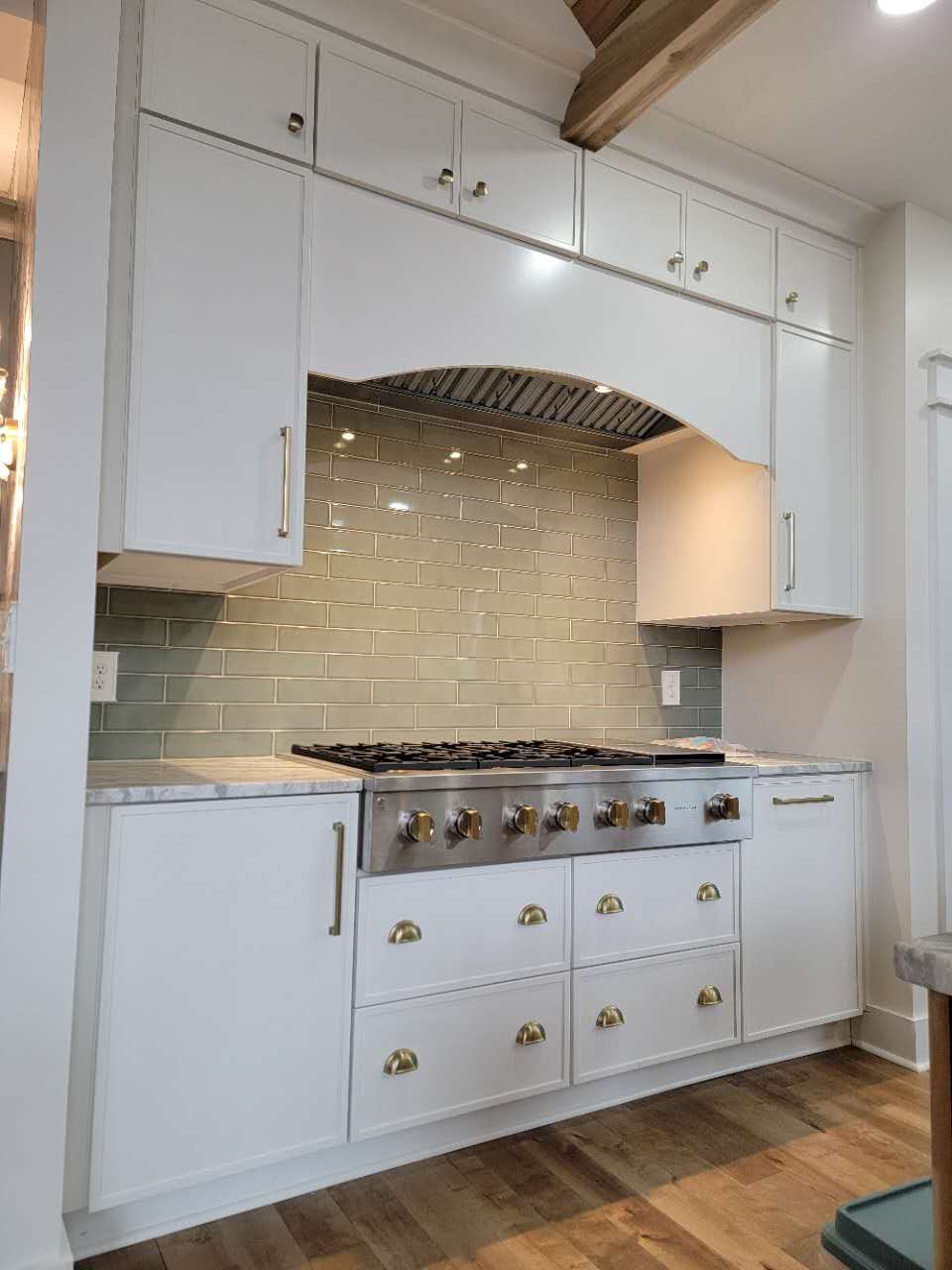 A kitchen with white cabinets and a stove top oven.