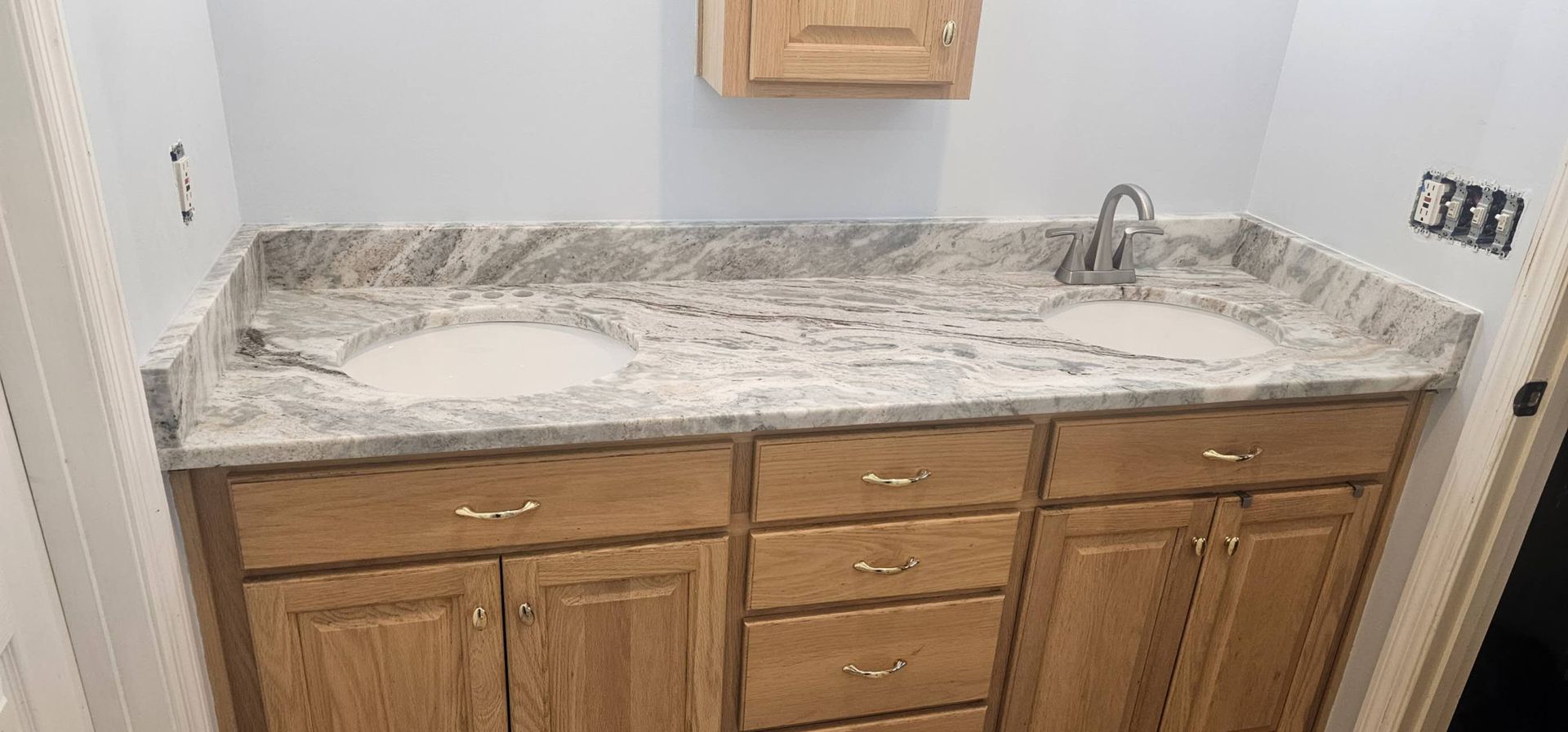A bathroom with two sinks and a granite counter top.