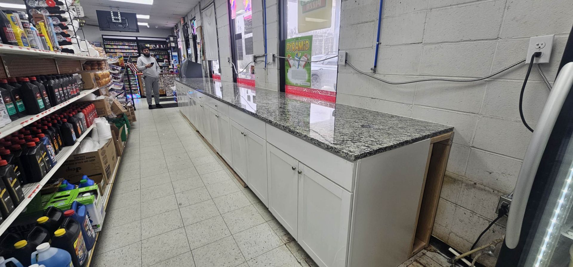 A long hallway in a grocery store with a granite counter top.