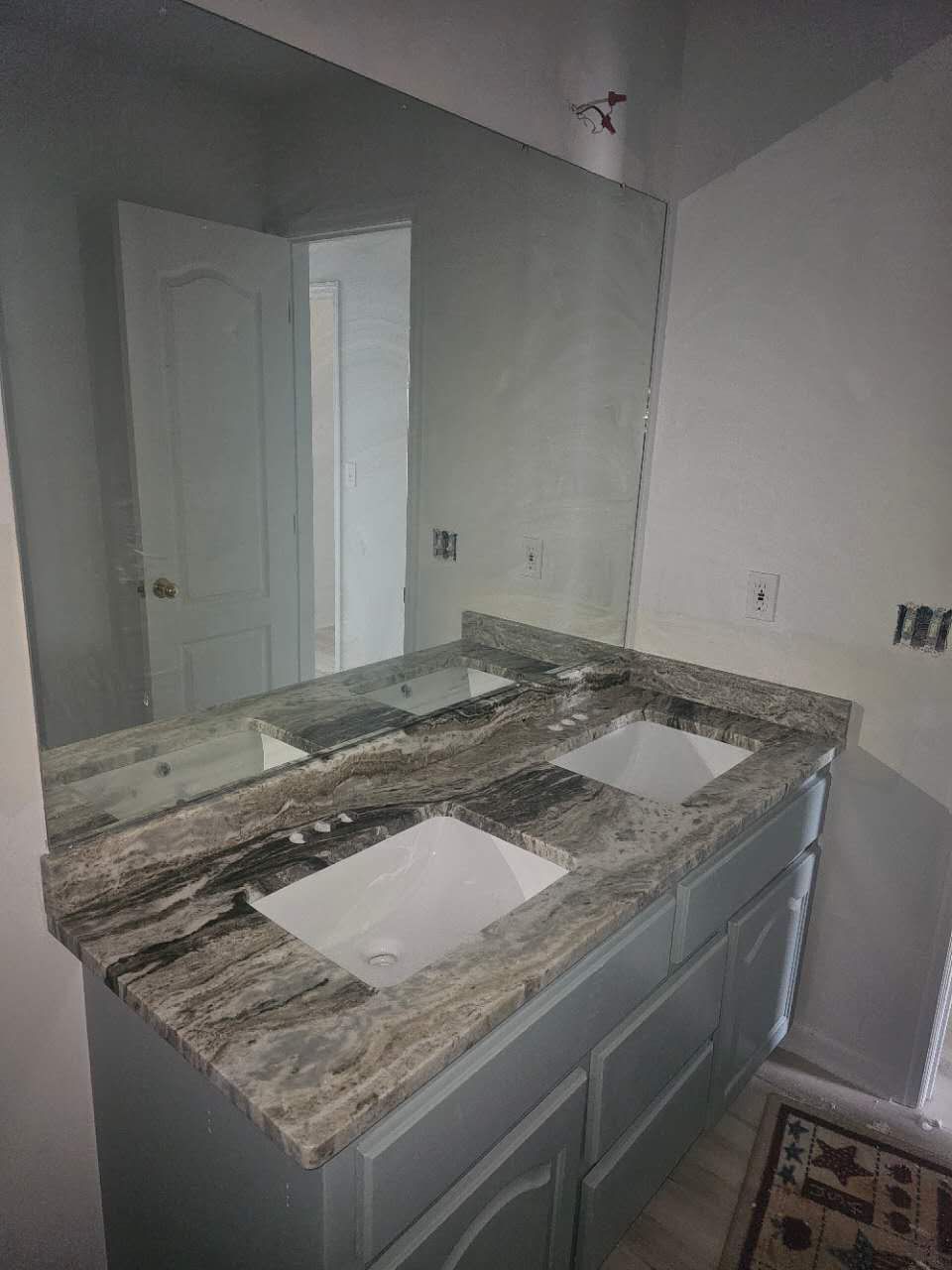 A bathroom with two sinks and a large mirror.