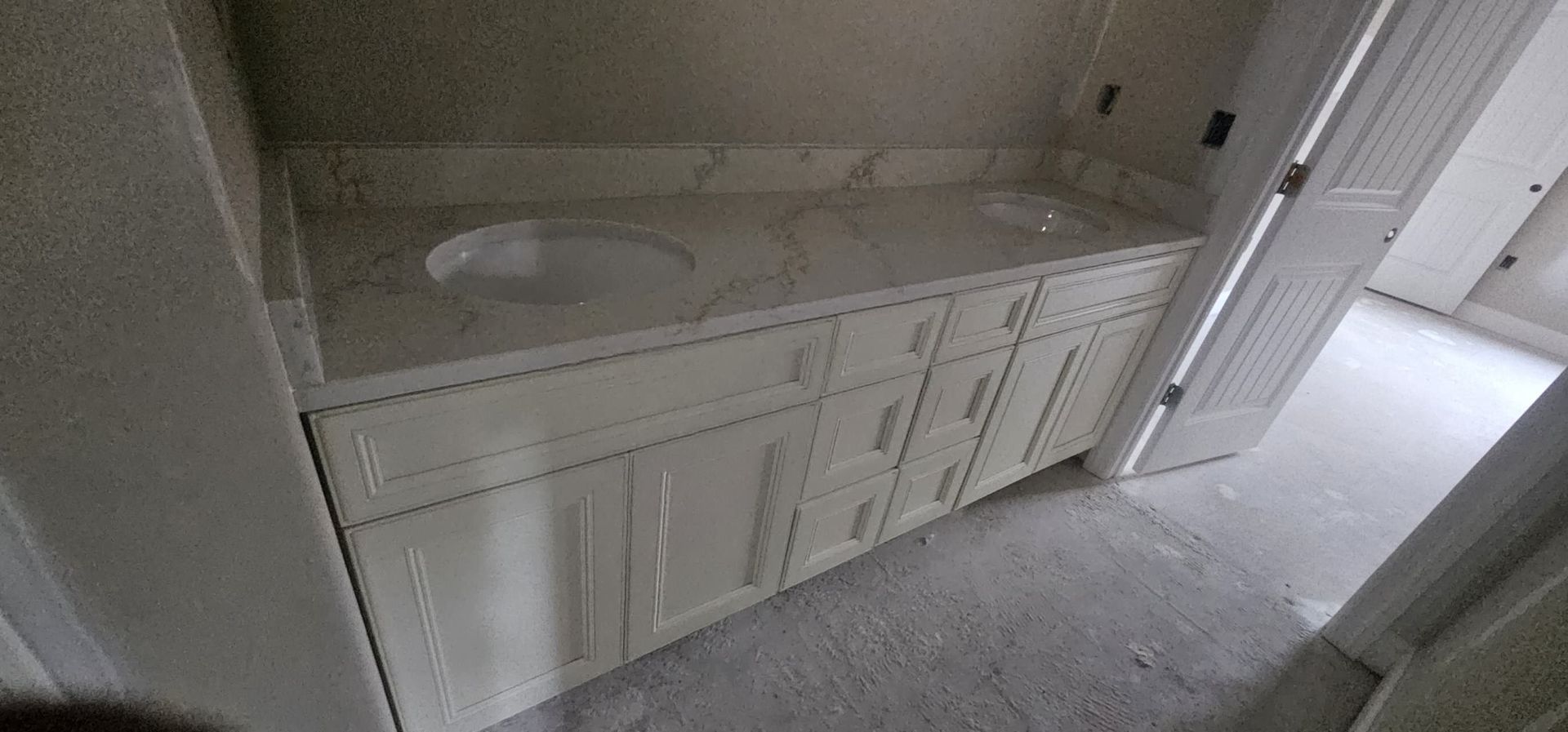 A bathroom with two sinks and white cabinets.