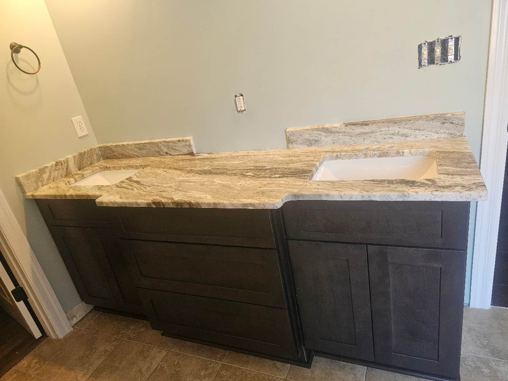 A bathroom with two sinks and granite counter tops.
