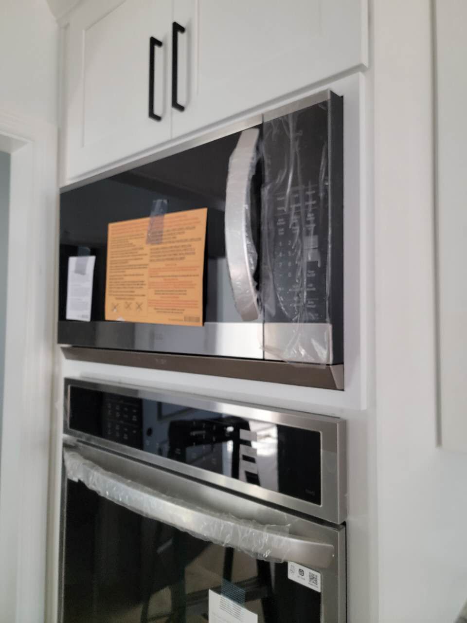 A stainless steel oven with a microwave above it.