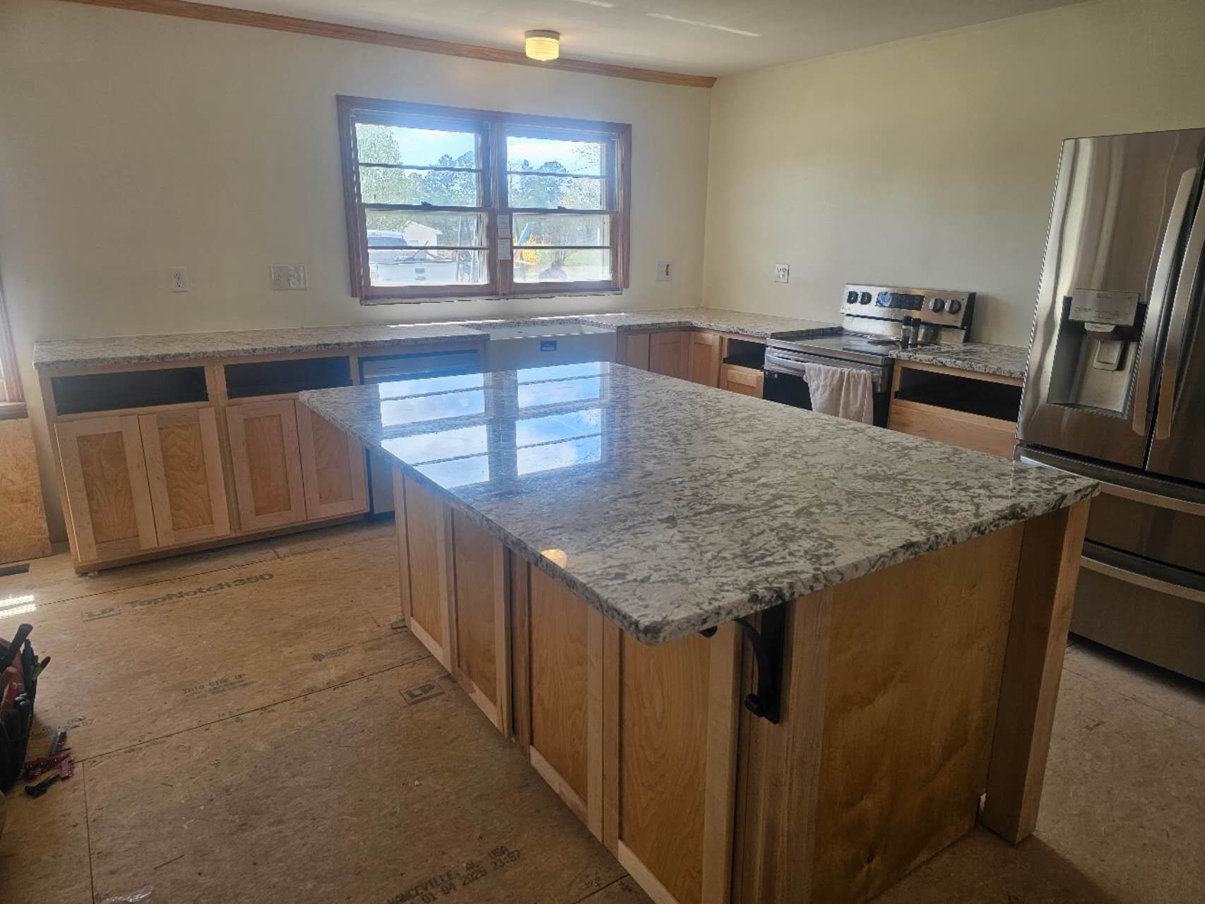 A kitchen under construction with a large island in the middle.