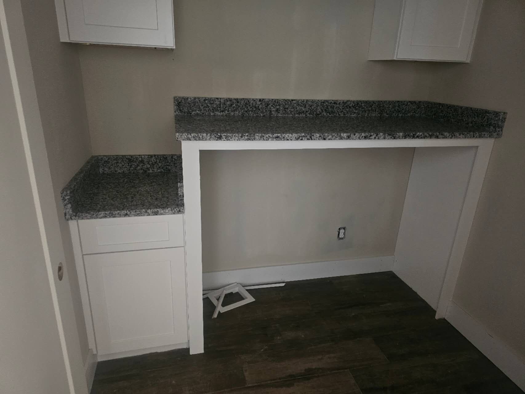 An empty room with a desk and cabinets in it.