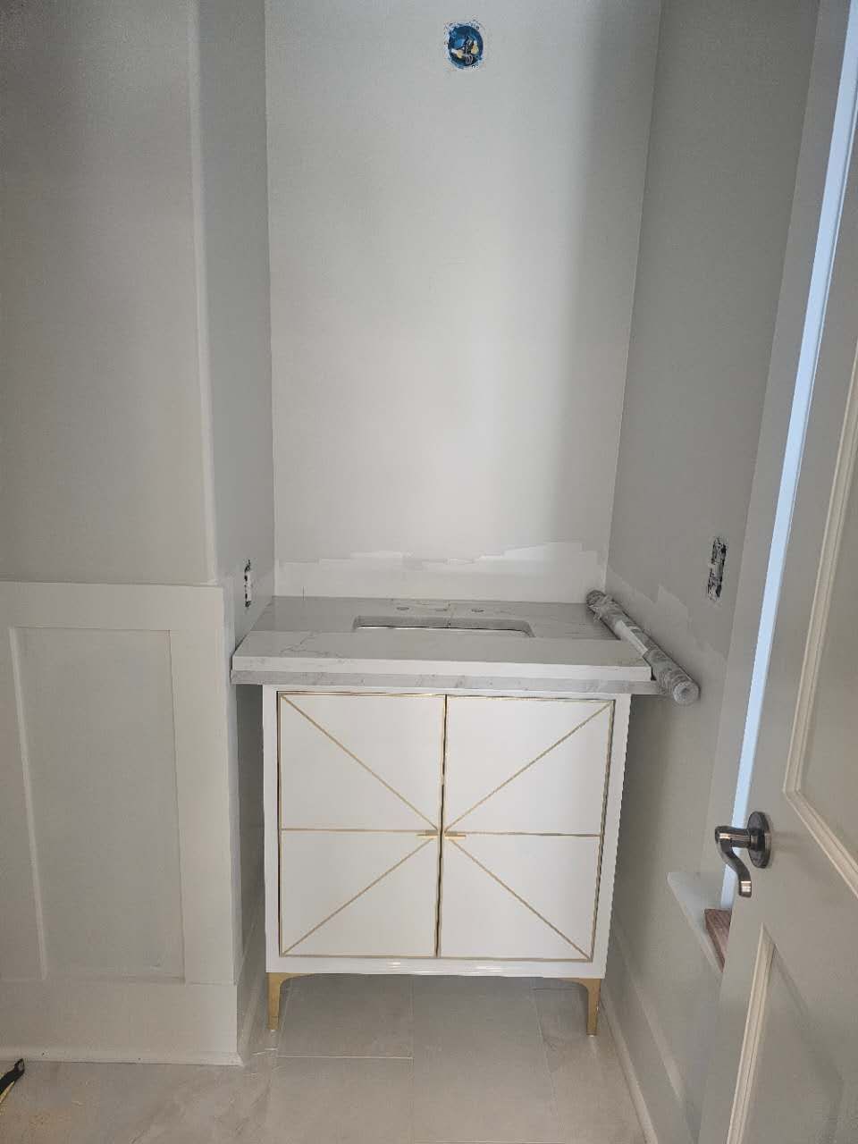 A bathroom with a white vanity and a sink.