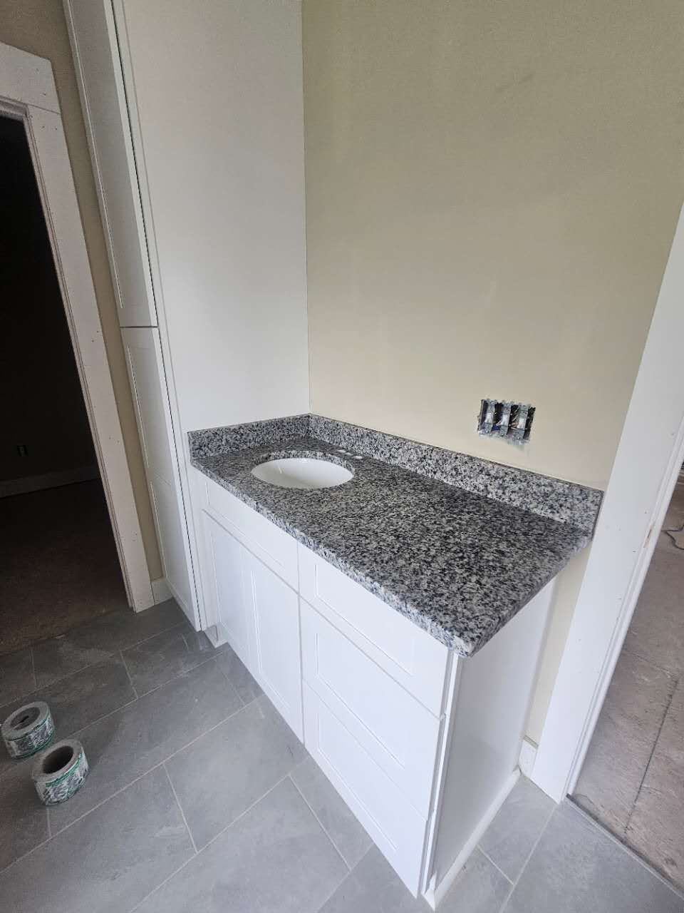 A bathroom with a sink and a granite counter top.