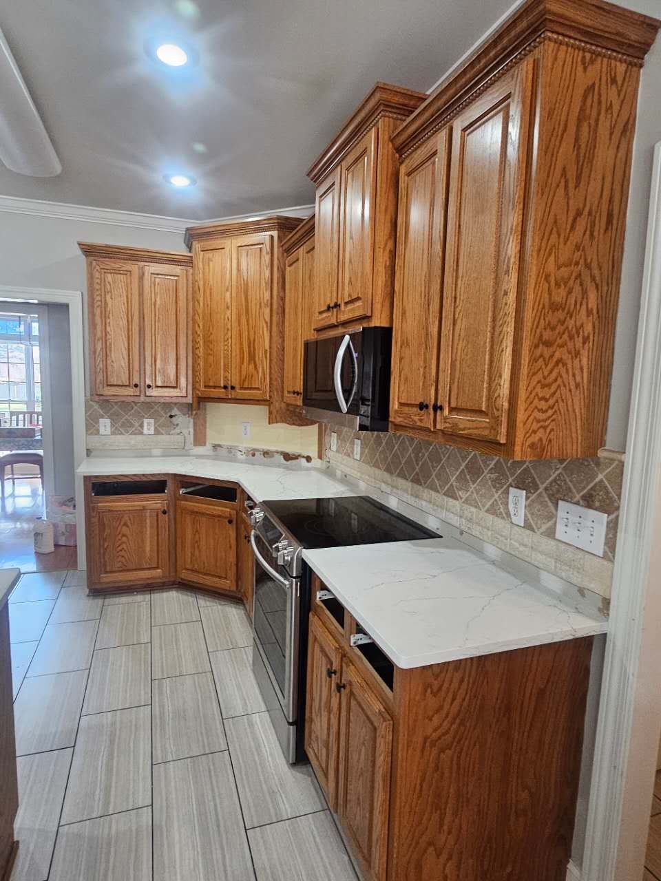 A kitchen with wooden cabinets, a stove, and a microwave.