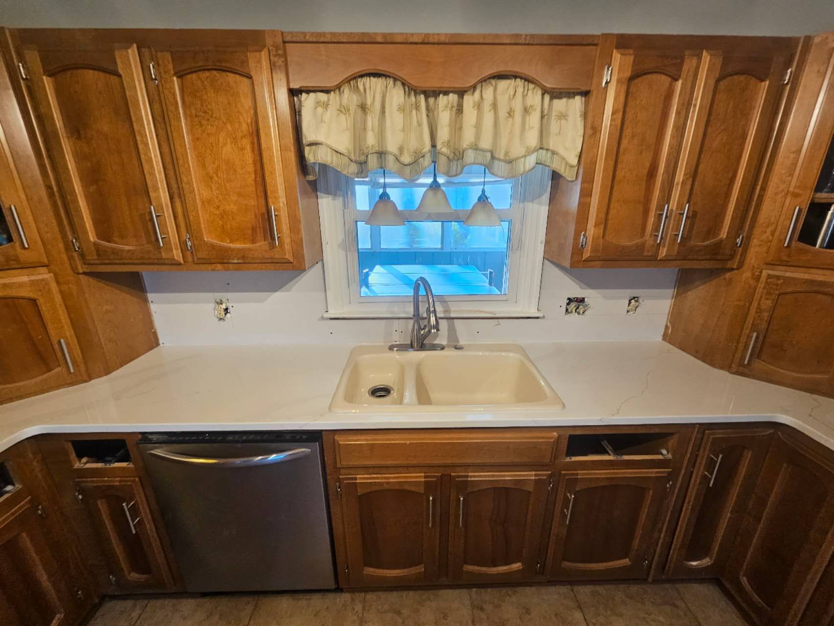 A kitchen with wooden cabinets and a sink and a window.