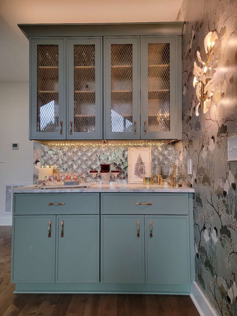 A kitchen with blue cabinets and a Christmas tree on the wall.
