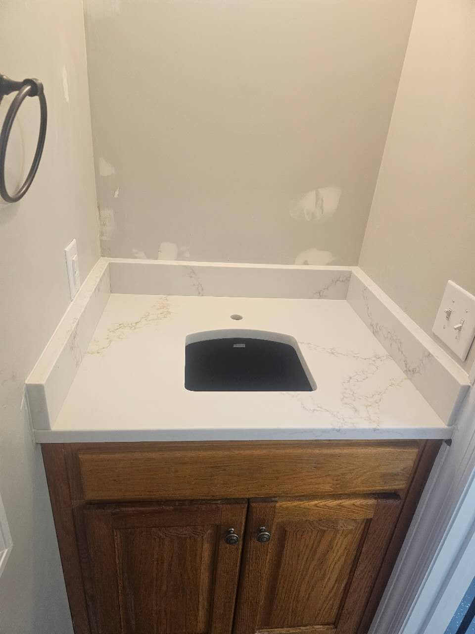 A bathroom vanity with a sink and a towel rack.