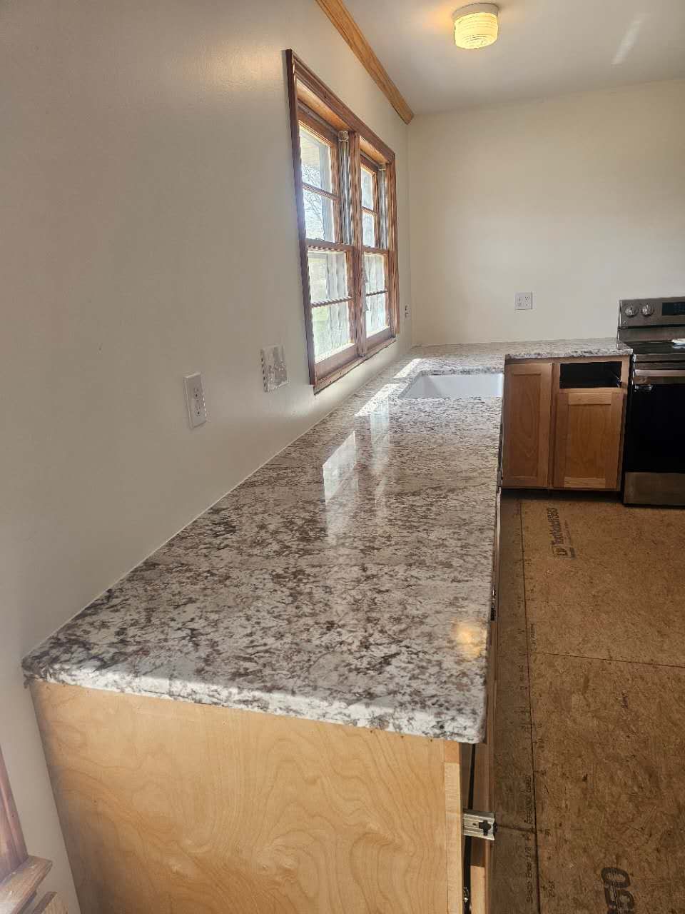 A kitchen with granite counter tops and wooden cabinets.