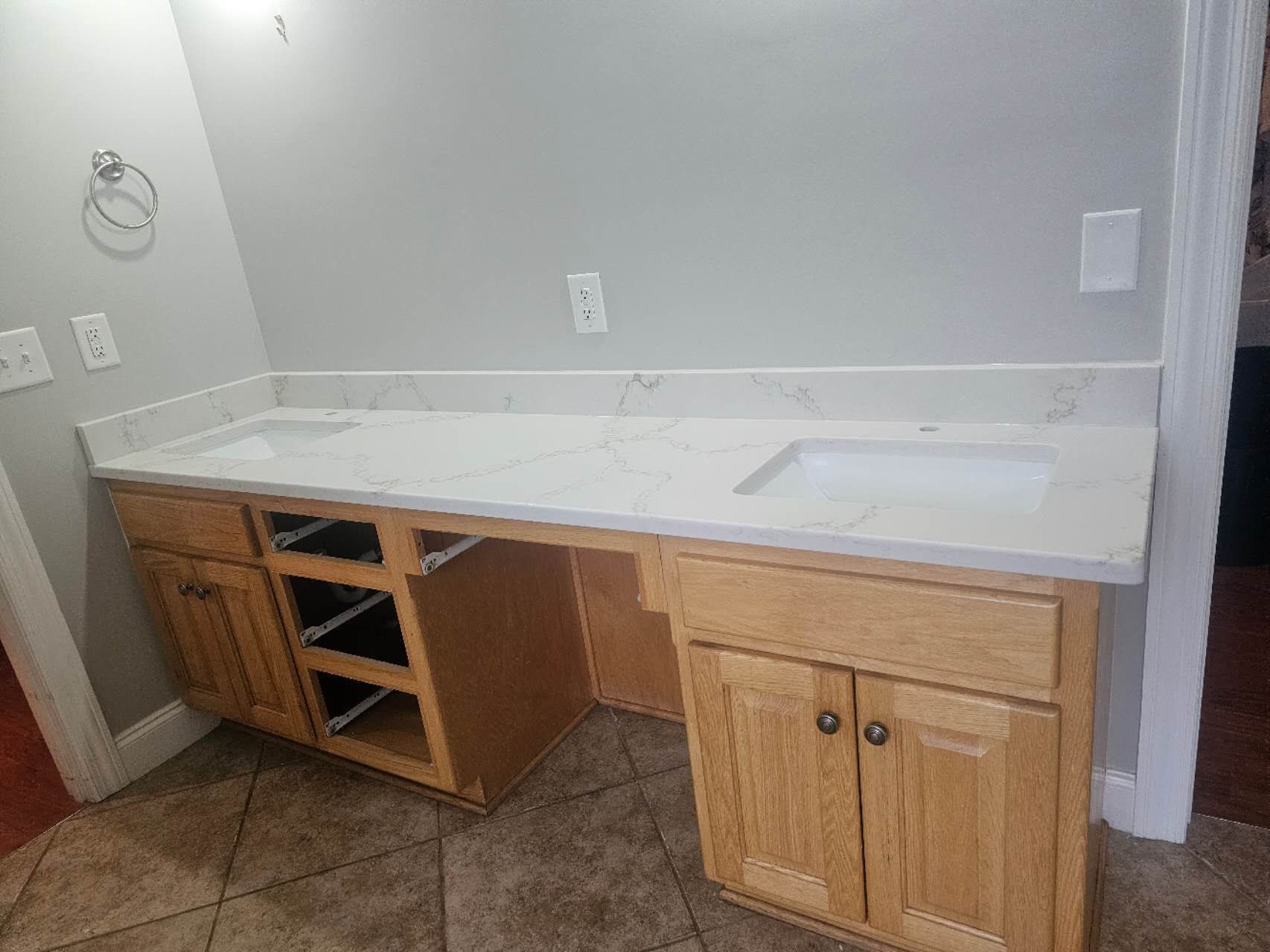 A bathroom vanity with two sinks and wooden cabinets.