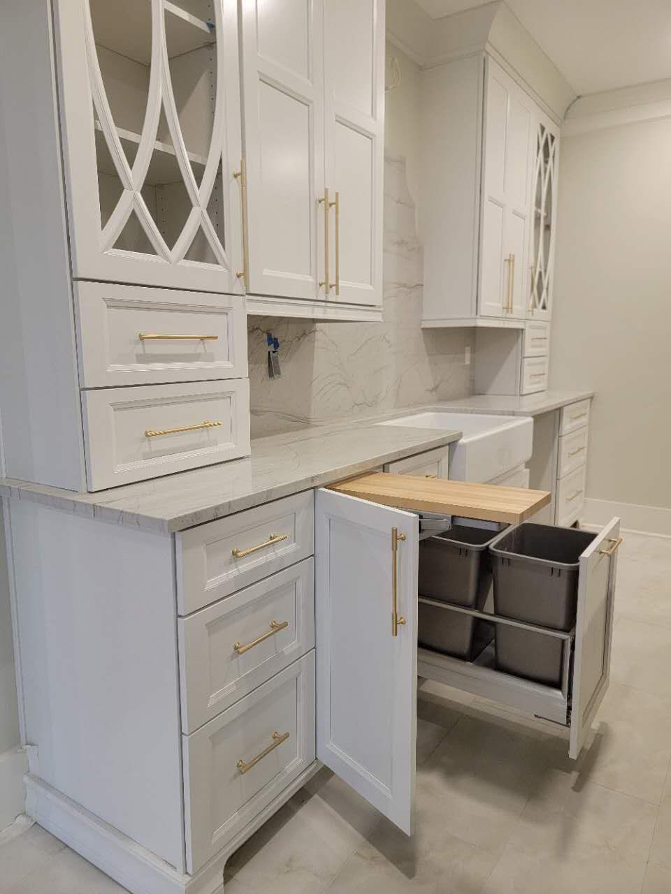 A kitchen with white cabinets and drawers and a sink.