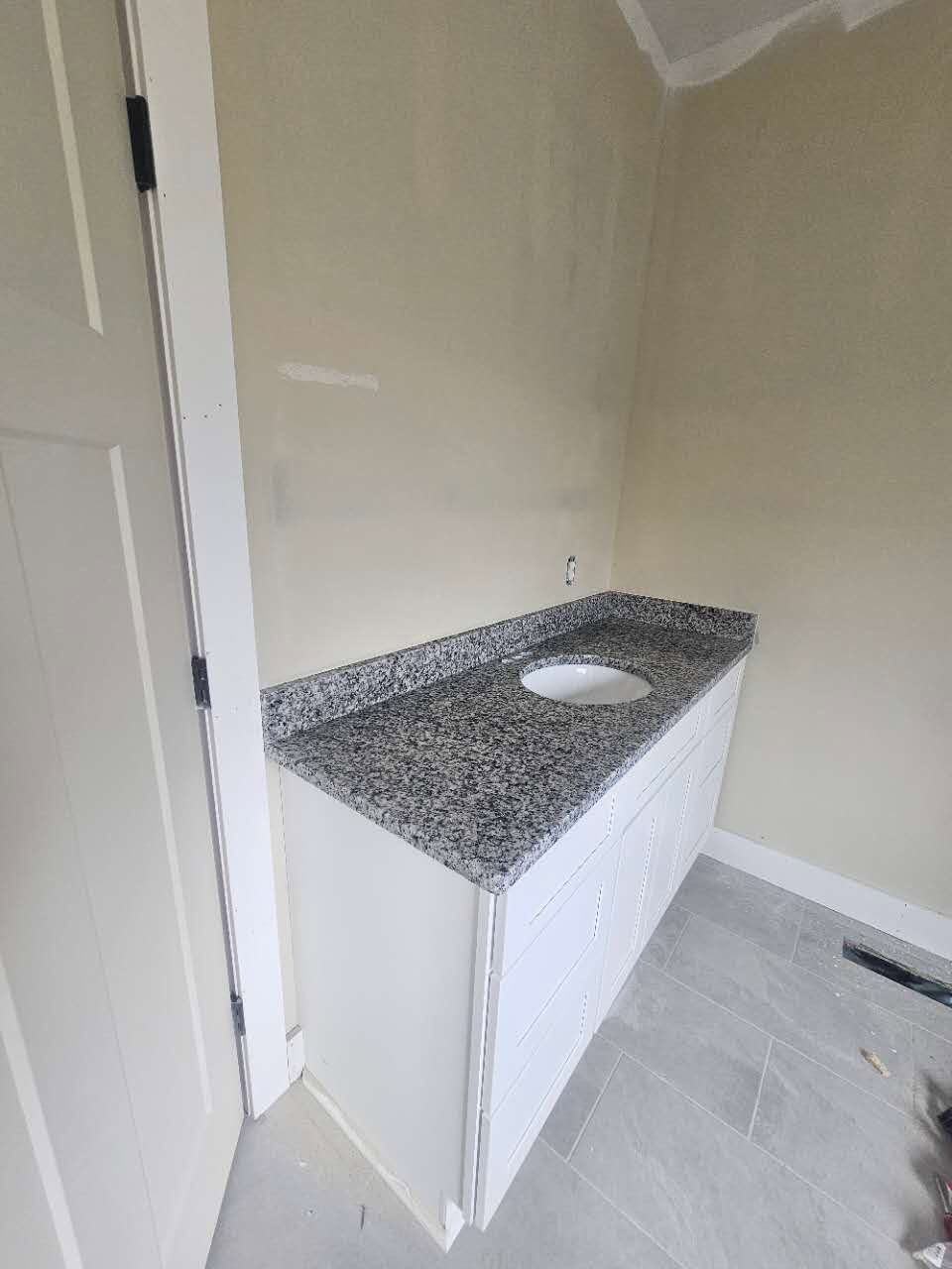 A bathroom with a granite counter top and a sink.