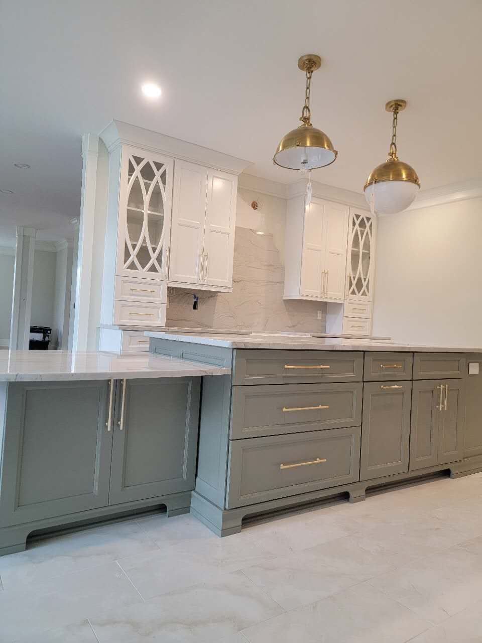 A kitchen with white cabinets and a large island in the middle.