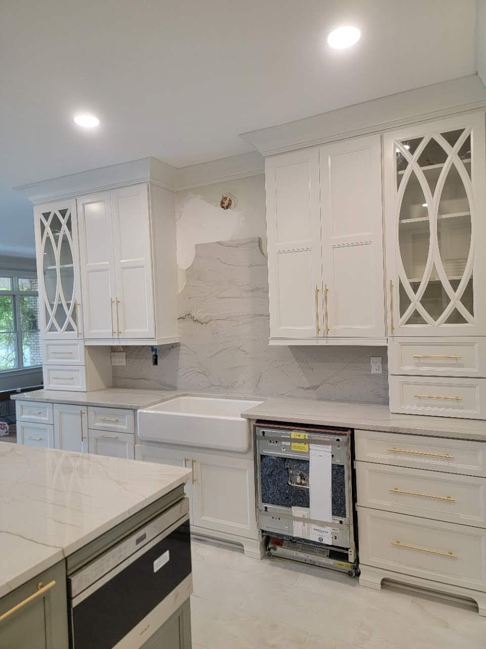 A kitchen with white cabinets, a sink, and a dishwasher.