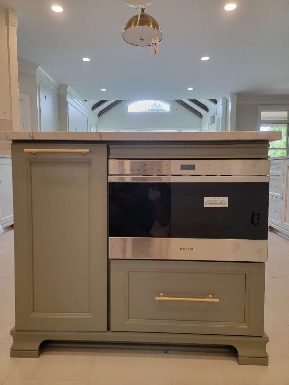 A kitchen island with a stainless steel oven and drawers.
