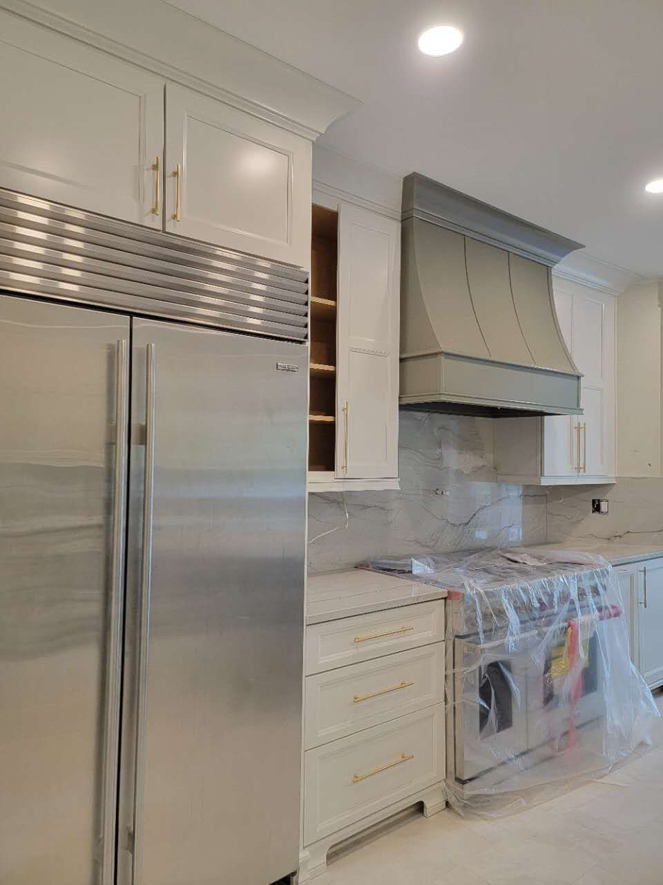A kitchen with stainless steel appliances and white cabinets.