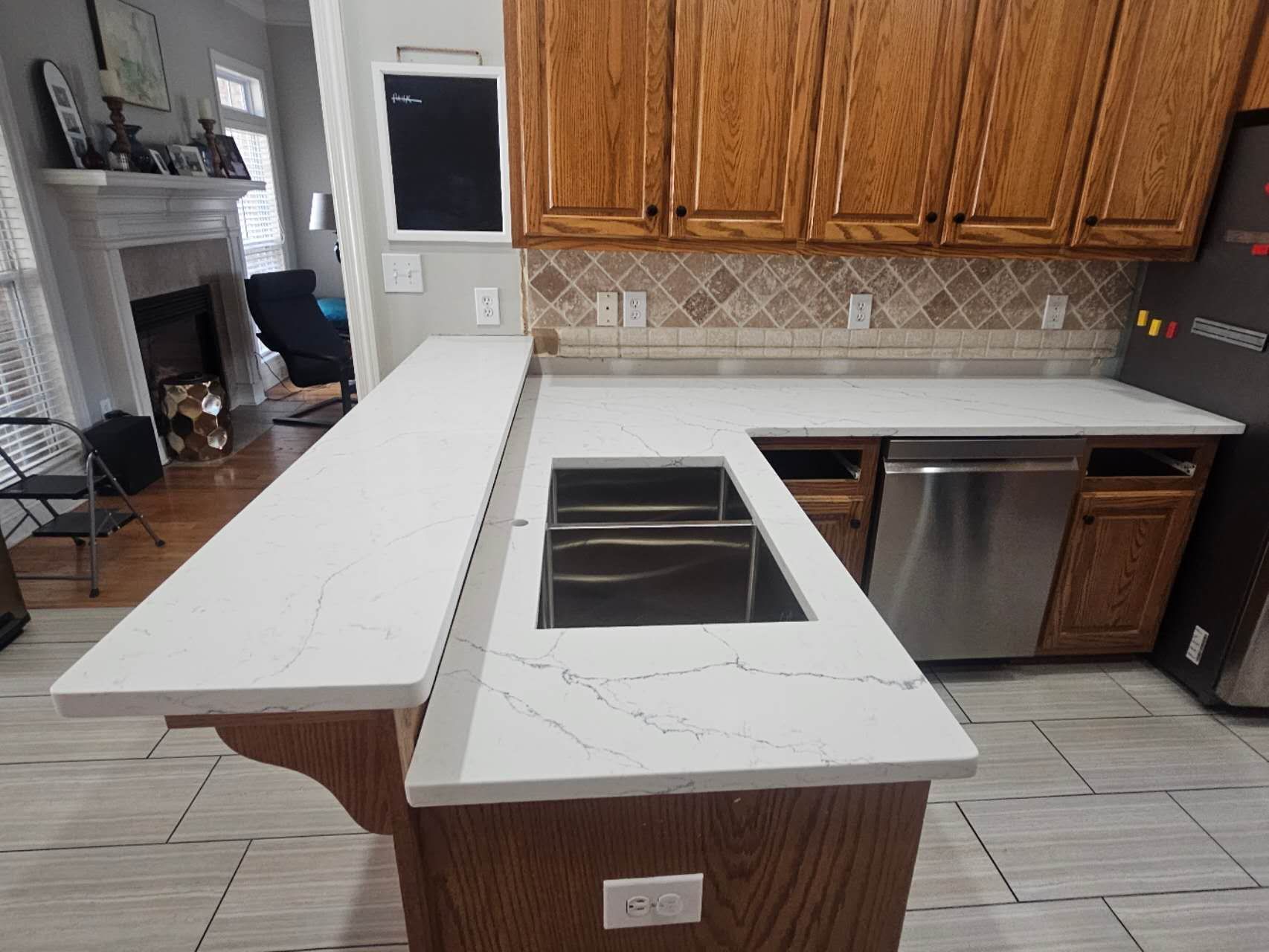 A kitchen with white counter tops and stainless steel appliances.