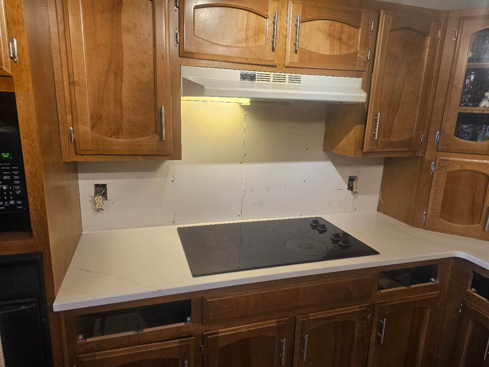 A kitchen with wooden cabinets and a stove top oven.