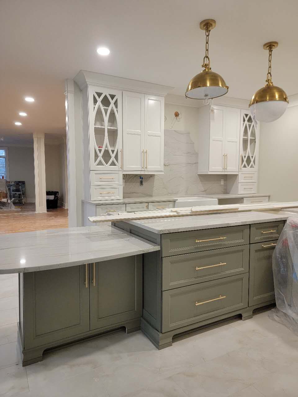 A kitchen with gray cabinets and white counter tops is being remodeled.