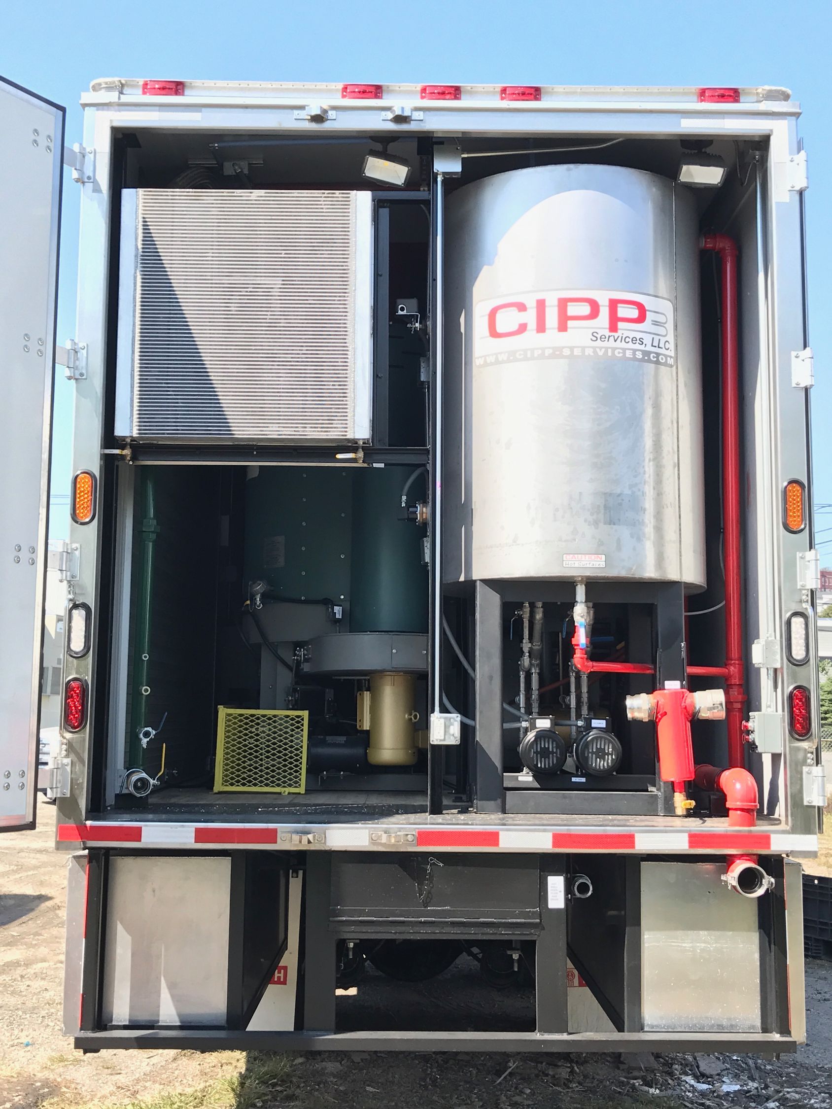 Interior of a truck with industrial equipment including a large tank labeled 