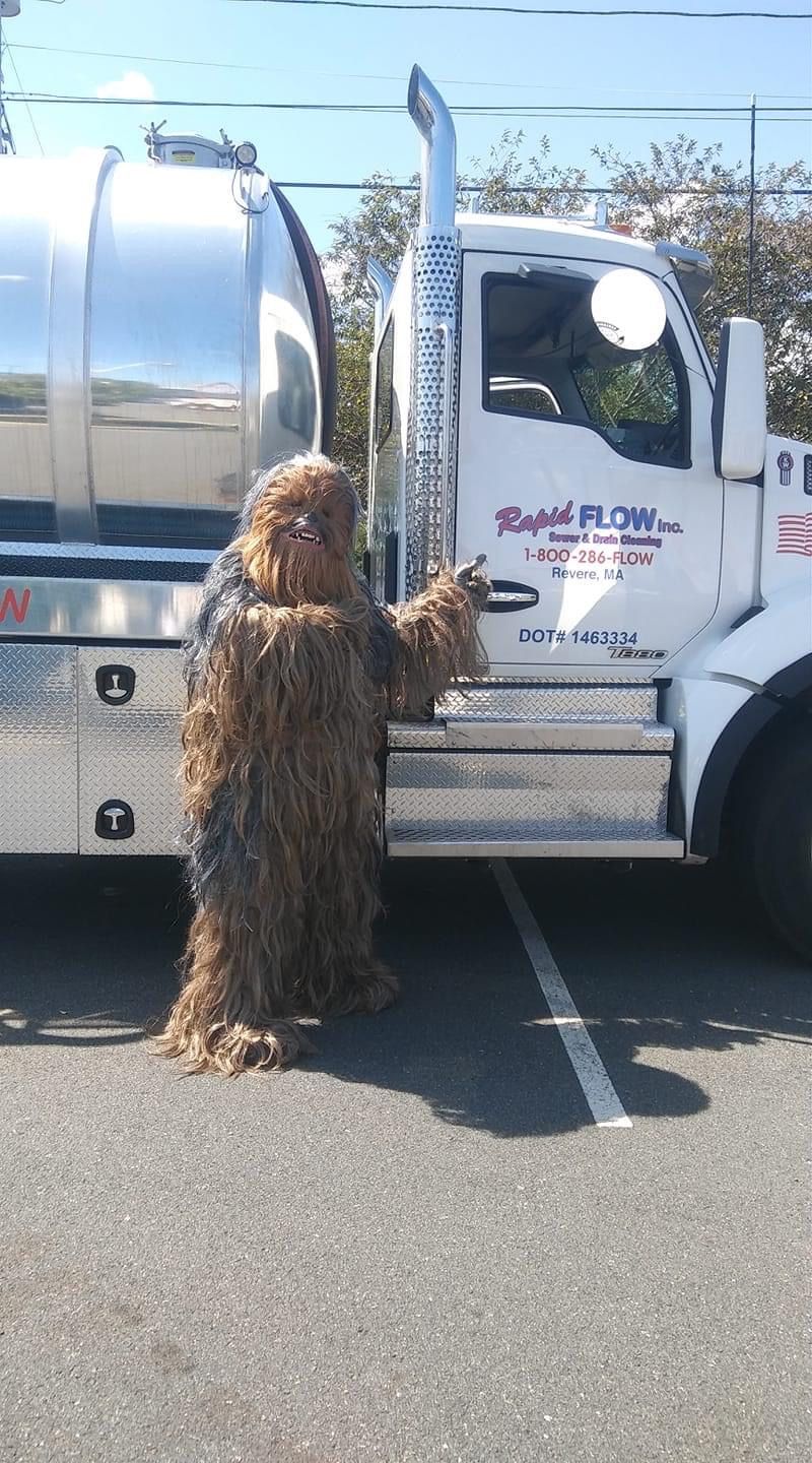 Chewbacca stands next to a white tanker truck.