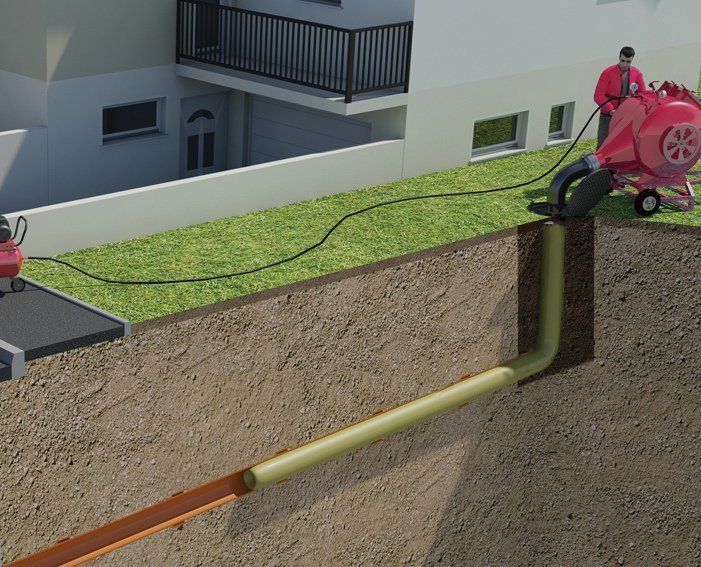 A machine injecting a new pipe into an underground damaged pipe on residential property.