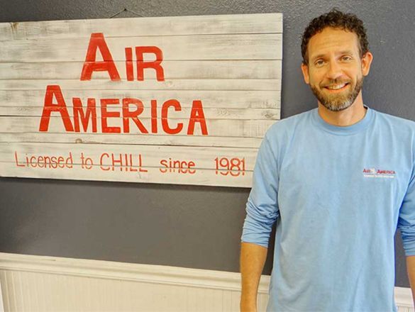 A man is standing in front of a sign that says Air America.