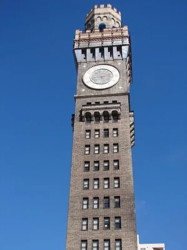 Clock tower on a brick building against a clear blue sky.