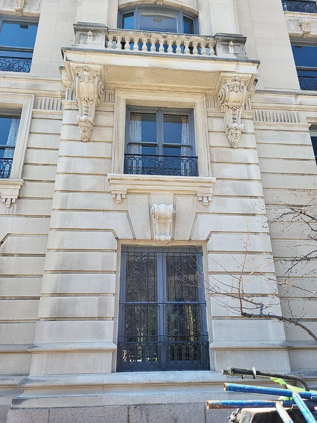 Stone building facade with ornate window and door details.