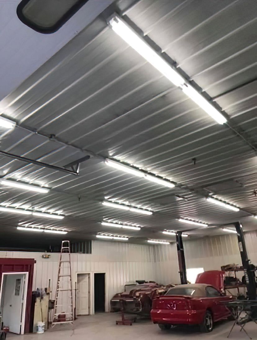 Spacious living room with fireplace, dark sofa, patterned rug, and large windows with light brown shades.