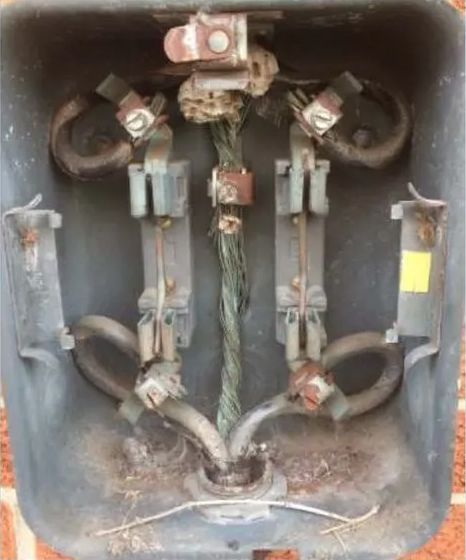 Electrical junction box with corroded wiring and fuses.