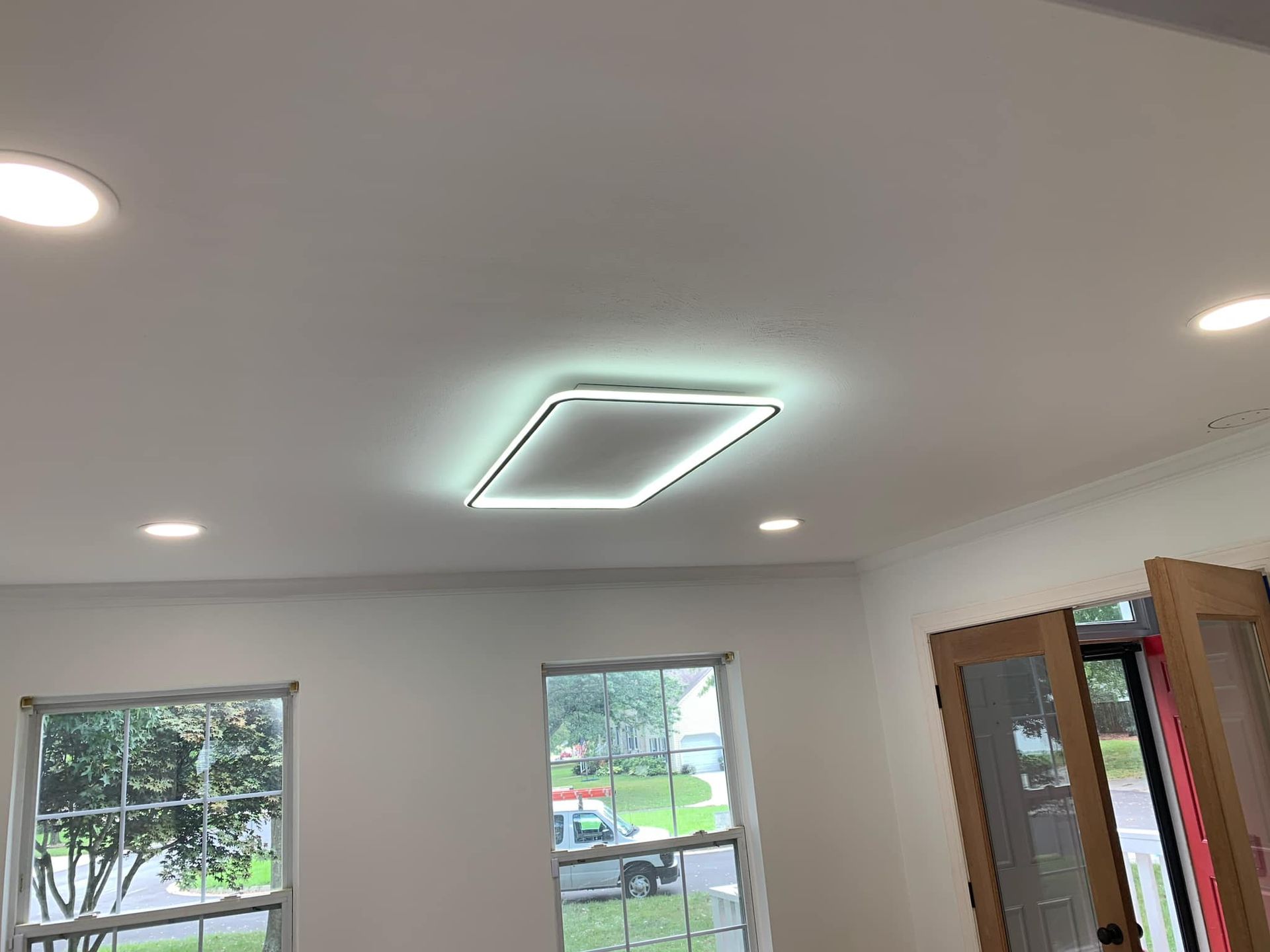 White ceiling with recessed lights, and a rectangular light fixture with a glowing border.