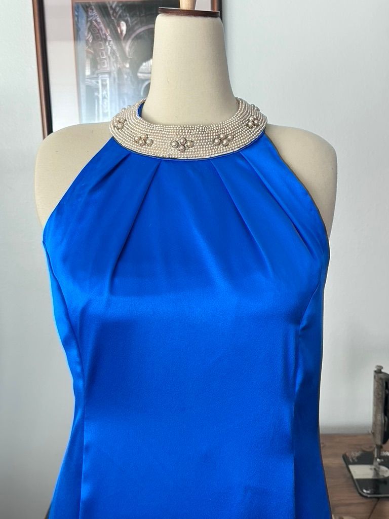 Blue satin dress on a mannequin with beaded collar.