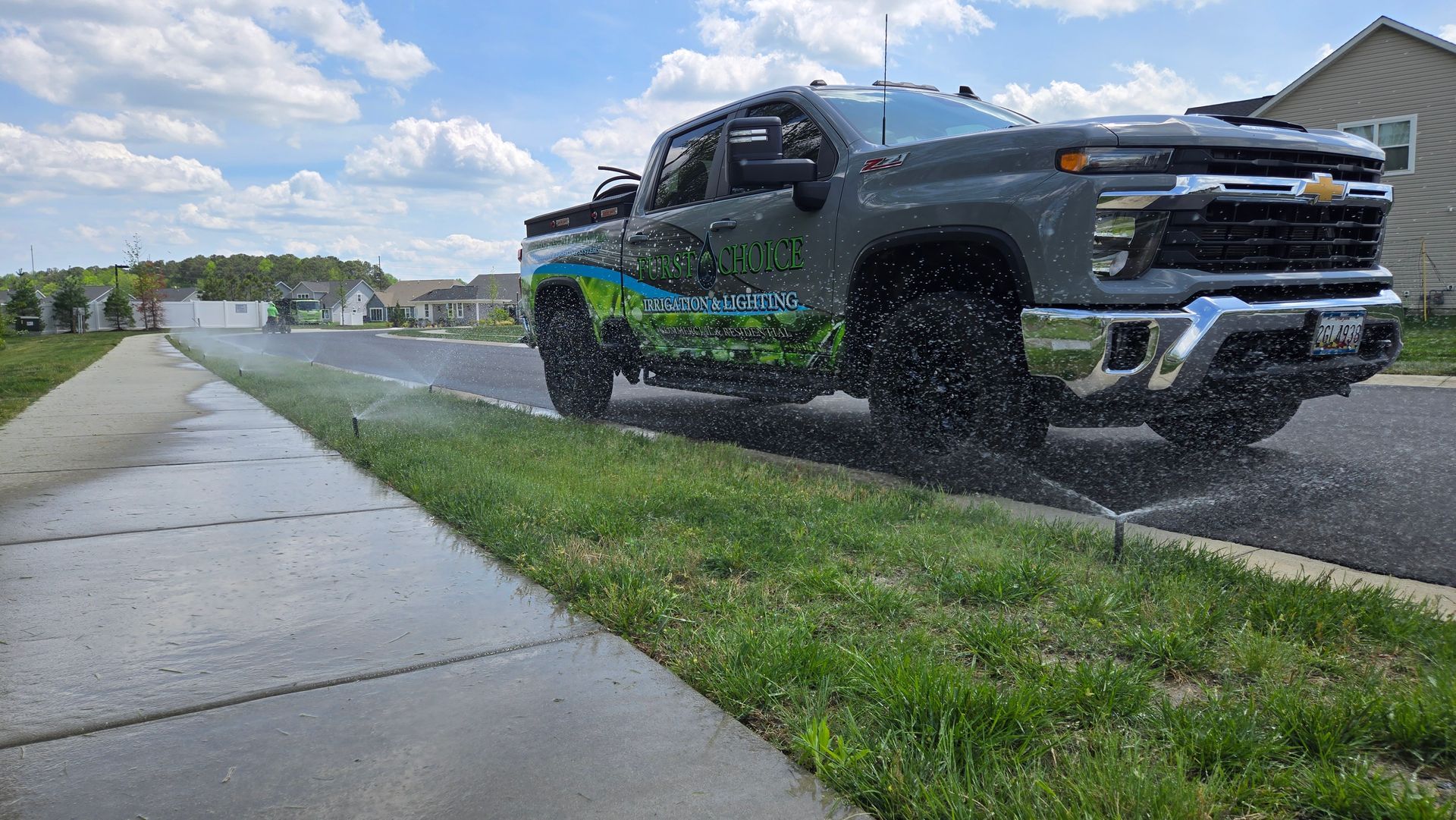A truck is parked on the side of the road next to a sidewalk.