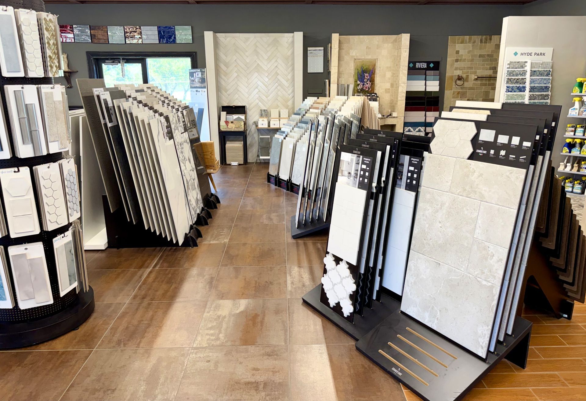Tile showroom with large stone and ceramic sample displays on wood floors